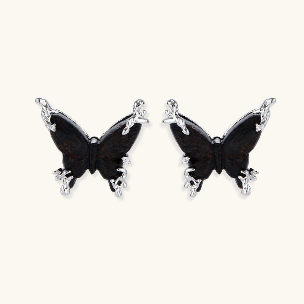 Wooden butterfly earrings with silver chain details in light and dark wood variants on white background