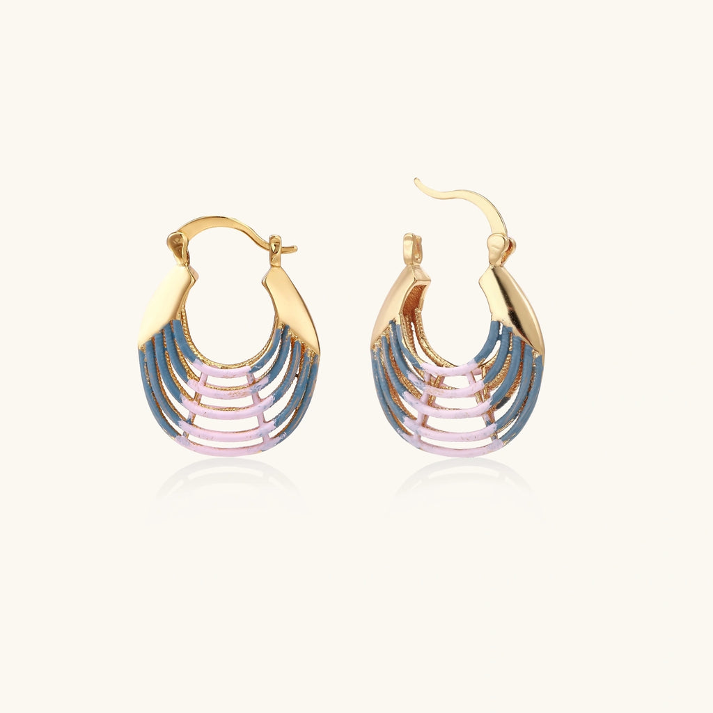 Gold hoop earrings with gradient blue-to-pink enamel in ribbed fan design on beige background